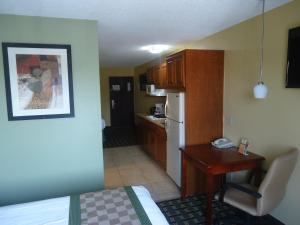 een kleine kamer met een keuken en een bureau in een hotelkamer bij TownHouse Extended Stay Hotel Downtown in Lincoln