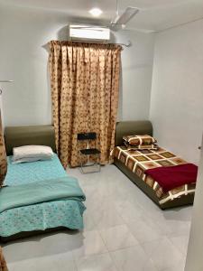 A bed or beds in a room at Lakse Inn Homestay