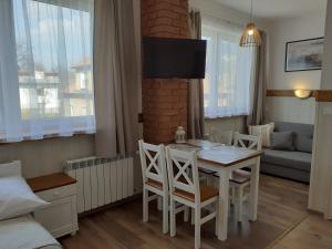 a living room with a table and chairs and a couch at Apartamenty nad Jeziorem in Międzybrodzie Żywieckie
