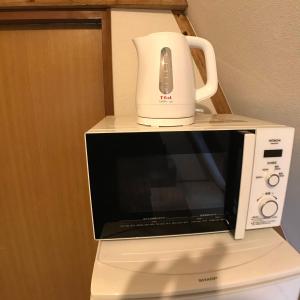 un microondas blanco con una licuadora encima en 南箱根ツリーハウス en Kannami