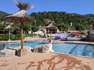ニヨンにあるMaisonnette dans domaine avec piscine à Nyons, pays des olivesのスイミングプール(傘付)
