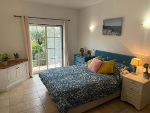 um quarto com uma cama e uma grande janela em Spacious 3 bedroom villa with pool na Praia da Luz
