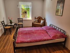1 dormitorio con 1 cama con edredón morado en EHM Family Resort, en Mesteri
