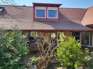 une maison avec une fenêtre rouge sur le toit dans l'établissement EHM Family Resort, à Mesteri