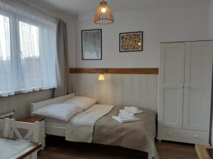 a small bedroom with a bed and a window at Apartamenty nad Jeziorem in Międzybrodzie Żywieckie