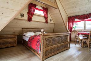 ein Schlafzimmer mit einem Bett in einer Blockhütte in der Unterkunft udanypobyt Domki Przy Potoku in Zakopane