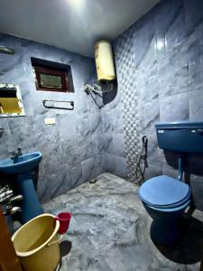 uma casa de banho com um WC azul e um lavatório. em MAGIC MIST RESORT em Ooty