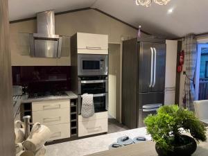 una cucina con piano cottura e frigorifero di Troutbeck Hot Tub Lodge 4 a Windermere