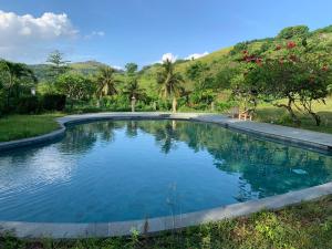 a swimming pool with blue water in a yard at Lombok Villas, Villa PaoPao in Labuhanpoh