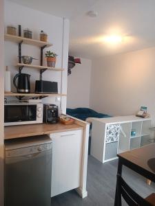 eine kleine Küche mit einer Mikrowelle und einem Tisch in der Unterkunft Studio Gruissan La Presqu'île 2 in Gruissan