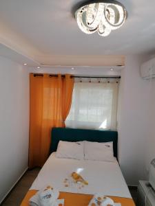 a bedroom with a bed and a chandelier at Crystal Blue Apartments in Nea Kalikratia
