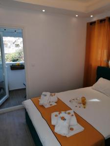 a hotel room with a bed with towels on it at Crystal Blue Apartments in Nea Kalikratia