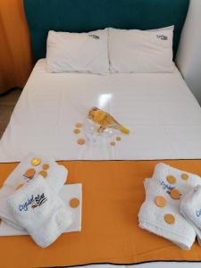 a hotel room with a bed with towels and a bird on it at Crystal Blue Apartments in Nea Kalikratia