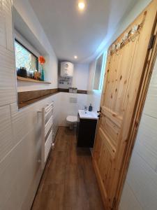 a bathroom with a toilet and a wooden door at Ferienhaus Helmig in Kurort Gohrisch