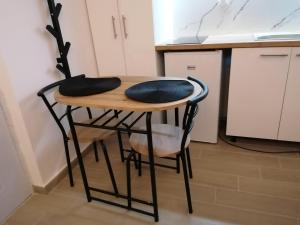 a small table with two chairs and a kitchen at Crystal Blue Apartments in Nea Kalikratia