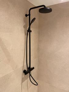 Varita de ducha en el baño con una luz en la pared en De Betze - Country Life, en Geetbets