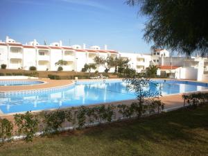 a large swimming pool in front of a building at Renovated Algarve Apartments with Pool in Armação de Pêra