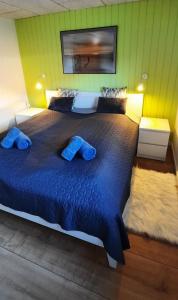 - une chambre avec un grand lit et 2 oreillers bleus dans l'établissement Gadegaard Apartment, à Ringkøbing