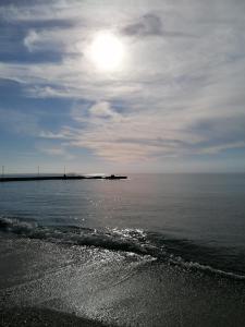 a beach with the sun in the sky and the ocean at Crystal Blue Apartments in Nea Kalikratia