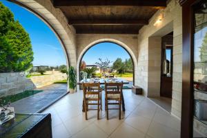 an outdoor patio with an archway and a table and chairs at FOS residence - ΦΩΣ ,luxury house in Chania