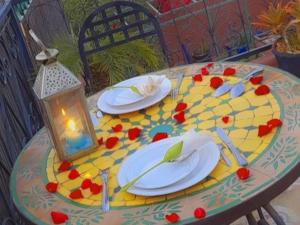 una mesa con platos y una linterna y una vela en Riad Bibtia, en Marrakech
