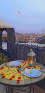 una mesa con platos y una lámpara en el balcón en Riad Bibtia, en Marrakech