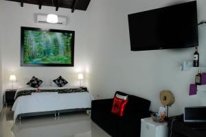 a bedroom with a bed and a flat screen tv at La Cabrera Hotel Boutique in Neiva