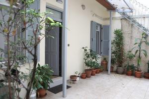 um pátio com vasos de plantas ao lado de uma casa em Όμορφο διαμέρισμα σε διατηρητέο κτίσμα στην Αθήνα em Atenas