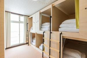 a room with bunk beds and a window at UNPLAN Village Hakuba in Otari