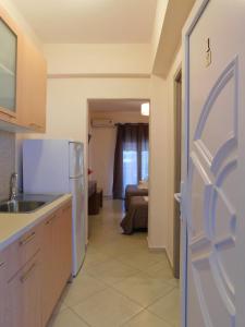 a kitchen with a refrigerator and a room with a bed at Anna house 1 in Sarti