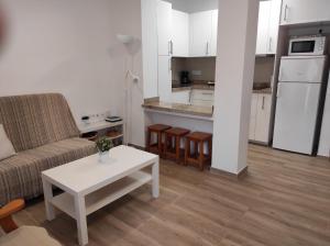a living room with a couch and a table and a kitchen at APARTAMENTO en PLAYA CALERA in Valle Gran Rey