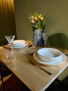 a table with two plates and a vase of flowers at The Nook, Morpeth Town in Morpeth