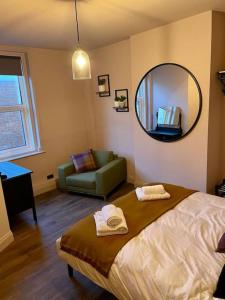 a bedroom with a bed and a mirror and a couch at The Nook, Morpeth Town in Morpeth
