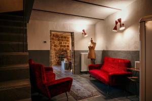 a living room with red chairs and a mirror at B&B La Castellina in Abbadia San Salvatore