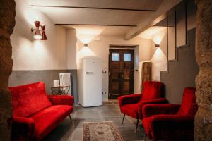 Habitación con sillas rojas y nevera blanca. en B&B La Castellina, en Abbadia San Salvatore