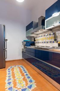 a kitchen with blue cabinets and a rug on the floor at Dimora del Fico - Appartamento elegante e spazioso in Naples