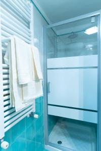 un bagno con piastrelle blu e doccia in vetro. di Dimora del Fico - Appartamento elegante e spazioso a Napoli
