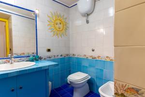 a blue bathroom with a toilet and a sink at Dimora del Fico - Appartamento elegante e spazioso in Naples