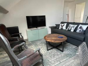 a living room with a couch and a table at Les Lodges du Castel in Châteauvillain