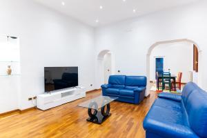 a living room with blue couches and a tv at Dimora del Fico - Appartamento elegante e spazioso in Naples