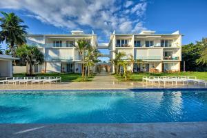 a house with a swimming pool in front of a building at Amazing ocean view apartment with grand pool in Cabarete