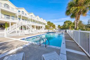 a swimming pool in front of a building with a resort at Beach Blessings Luxe 30A Townhome 2BR 3Bath, Walk to Beach, Pool, Hot Tub in Santa Rosa Beach