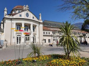 a large white building with flowers in front of it at Meranosuites - Therme in Merano
