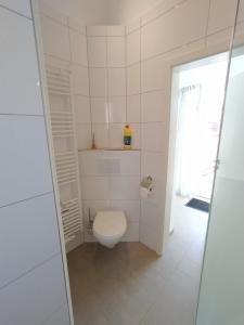 a bathroom with a white toilet in a room at Holiday Bungalow am Quendorfer See in Schüttorf