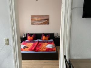 a bedroom with a bed with orange pillows at Doedelmoker in Wilhelmshaven