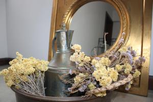 un vaso pieno di fiori davanti a uno specchio di 19 Oda Bozcaada a Çanakkale
