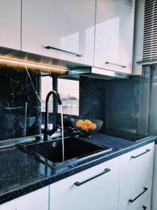 a kitchen with a sink and a bowl of fruit at thesstay Attica downtown boutique apartment in Thessaloniki