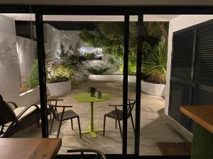 een patio met een groene tafel en stoelen bij LUZZ me - Casa de Angra in Angra do Heroísmo