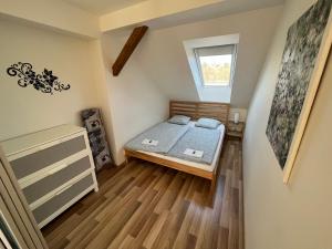 a small bedroom with a bed and a window at Apartmány Skryjova in Brno