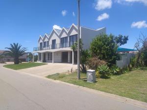 a large white house on the side of a street at Alive@4 in Mossel Bay